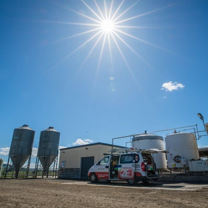 Solar installation in Hamilton and Waikato – 2E Electrical van on site at a rural farm facility under clear blue skies with strong sunlight, highlighting solar energy potential