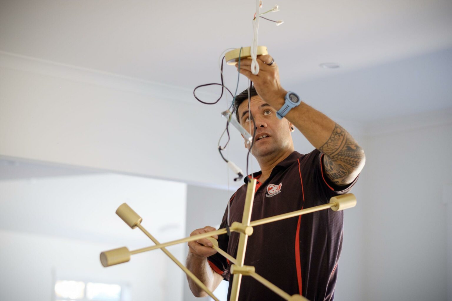 Hamilton Electrician installing modern designer light fitting in residential home