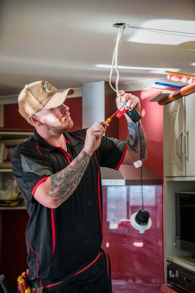 Electrician Hamilton installing ceiling light wiring in a kitchen