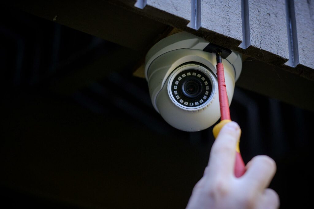 Close-up of CCTV security camera being installed under eaves by a 2E Electrical technician